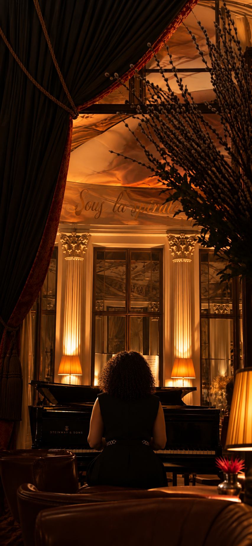 Une femme au piano dans un salon éclairé de lumière dorée